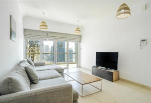 a living room with two couches and a flat screen tv at New Arabian - 8 Boulevard Walk Downtown Dubai in Dubai