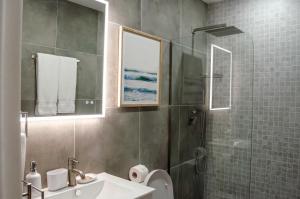 a bathroom with a shower and a sink and a toilet at The Palms Resort in Saint James