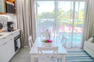 a kitchen with a table with a bowl of flowers on it at The Palms Resort in Saint James