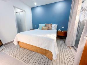 a bedroom with a large bed with a blue wall at The Palms Resort in Saint James