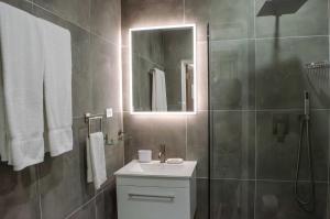 a bathroom with a sink and a shower with a mirror at The Palms Resort in Saint James