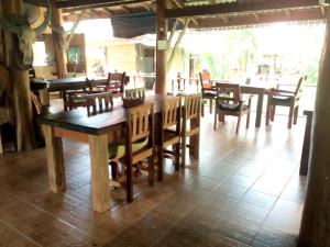 a dining room with wooden tables and chairs at Khao Sok Nung House in Khao Sok National Park