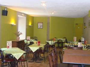 een eetkamer met groene muren en tafels en stoelen bij AUX GLOBE-TROTTERS in Murat