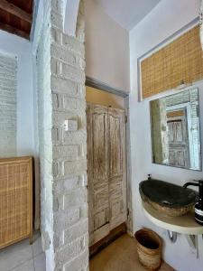 ein Badezimmer mit einem Waschbecken und einer Ziegelwand in der Unterkunft Villa Cabala Bali in Canggu