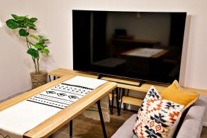 a living room with a table and a tv at ヒルトップ箱根　103 in Odawara