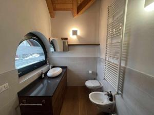 baño con lavabo y aseo y ventana en Casa Giuliana con SkiBus Gratis, en Aprica