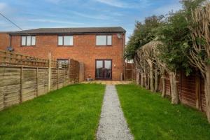 a brick house with a fence and a grass yard at 52 Carr Avenue in Leiston