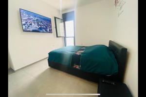 a bedroom with a green bed in a room at New- Luxury Glil Yam For Family 4 Rooms Parking in Herzliya