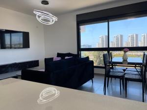 a living room with a couch and a table at New- Luxury Glil Yam For Family 4 Rooms Parking in Herzliya