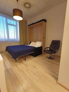 a bedroom with a bed and a chair in it at Zlatarooms 310 in Warsaw