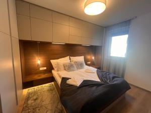 a bedroom with a large bed with a wooden headboard at Karzo Property LK 202 in Budapest