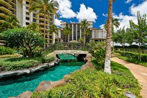 a bridge over a river in front of a building at Ko Olina Beach Villas O724 in Kapolei