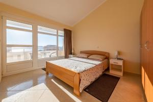 um quarto com uma cama e uma grande janela em VILLA Karolina by the sea em Sukošan