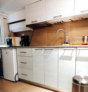 una cocina con armarios blancos y fregadero en Beautiful cozy apartment en Athens