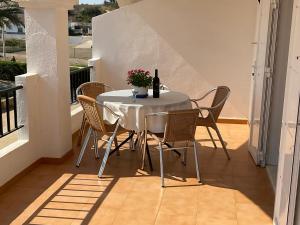 a white table with chairs and a bottle of wine at Apartamentos Turísticos Los LLanos in Cuevas del Almanzora