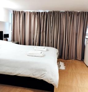 Schlafzimmer mit einem großen weißen Bett und Vorhängen in der Unterkunft Beautiful cozy apartment in Athen