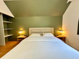 a bedroom with a large white bed with two lamps at My Little Home - Le Liberté 47 in Lille