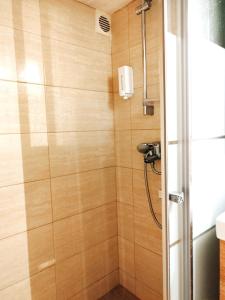 ein Bad mit einer Dusche und Holzwänden in der Unterkunft Beautiful cozy apartment in Athen