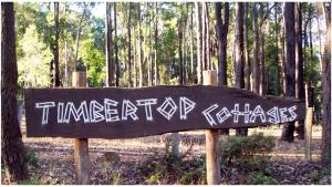 a sign with graffiti on it in a forest at Balingup TimberTop Cottages in Balingup