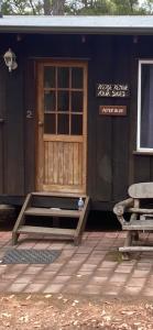 a house with a door and a bench in front of it at Balingup TimberTop Cottages in Balingup