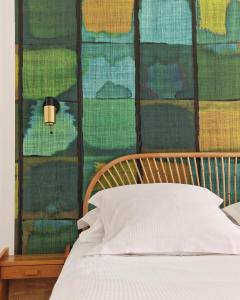 łóżko z drewnianym zagłówkiem i ścianą z: w obiekcie Louison Appart & Suite w mieście Quiberon
