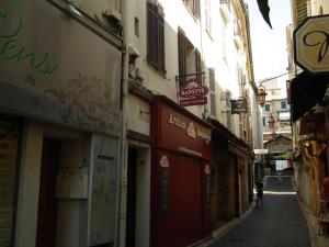 un vicolo con edifici e una persona che cammina per la strada di Coeur Vieil Antibes Plages à Pied a Antibes