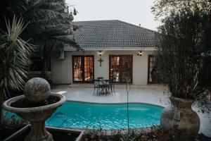 a house with a swimming pool with a fountain at The Symphony Guest House in Queenstown