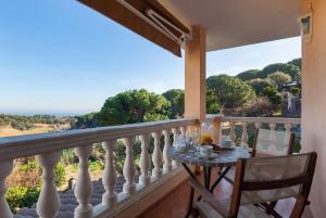 a table on a balcony with a view of the ocean at Villa Sol in Sant Cebrià de Vallalta