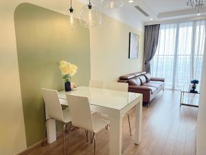 sala de estar con mesa, sillas y sofá en Vinhomes Times City 1BR, en Hanói