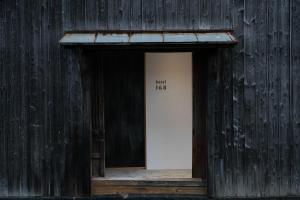 eine Tür in einem Holzgebäude mit den Worten "Steuern" in der Unterkunft Hagi Kannuki 168 -萩 閂いろは- in Hagi