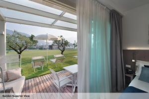 a bedroom with a balcony with a bed and a table at Seven Park Hotel Lake Como - Adults Only in Colico