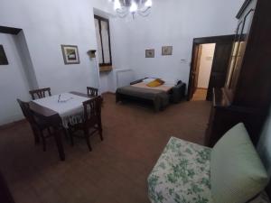 sala de estar con cama, mesa y sillas en casa vacanze San Lorenzo, en Viterbo