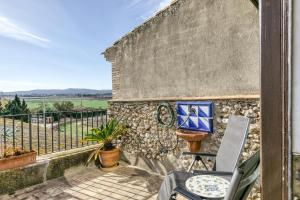 een balkon met een stoel en een stenen muur bij Can Roca in Montiró