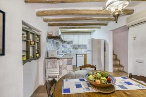een keuken met een tafel en een fruitschaal bij Can Roca in Montiró