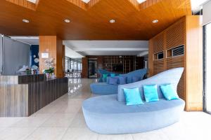 a lobby with two blue couches in a building at The Bedrooms Hostel Pattaya in Pattaya Central