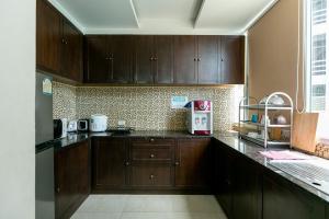 a kitchen with wooden cabinets and a counter top at The Bedrooms Hostel Pattaya in Pattaya Central