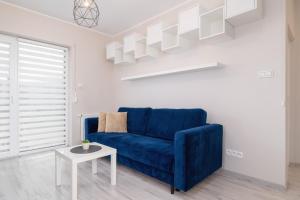 ソスノヴィエツにあるGround Floor Apartment with Garden and FREE GARAGE in Sosnowiec by Noclegi Rentersの青いソファとテーブルのあるリビングルーム