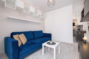 ソスノヴィエツにあるGround Floor Apartment with Garden and FREE GARAGE in Sosnowiec by Noclegi Rentersの青いソファとテーブルのあるリビングルーム +22枚の写真