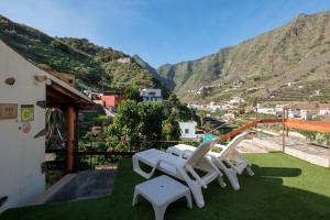 een groep witte stoelen op een balkon met uitzicht op de bergen bij Casa Rural Las Nuevitas I in Hermigua