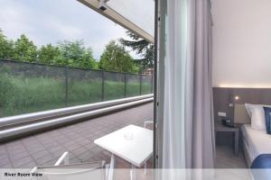 a room with a balcony with a bed and a window at Seven Park Hotel Lake Como - Adults Only in Colico