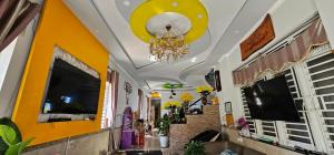 a hallway with yellow walls and a chandelier at QUEEN HOTEL Khách sạn QUEEN in Ngọc Tĩnh