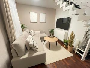 sala de estar con sofá y TV en Charmantes TinyHouse im Zentrum - MalliBase Apartments, en Hannover