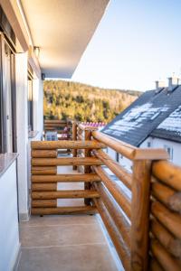 een balkon met houten leuningen op een huis bij Apartmaji Ježek Kope in Šmartno pri Slovenj Gradcu
