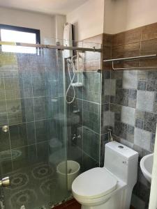 a bathroom with a toilet and a glass shower at Sassy's Place II in Baguio