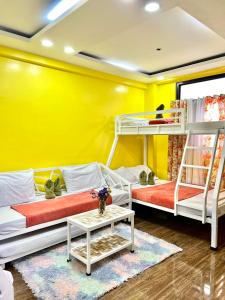 2 Etagenbetten in einem Zimmer mit gelber Wand in der Unterkunft Sassy's Place II in Baguio City
