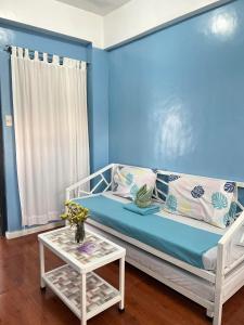 Habitación azul con sofá y mesa en Sassy's Place II, en Baguio