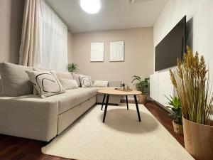 a living room with a couch and a table at Charmantes TinyHouse im Zentrum - MalliBase Apartments in Hannover +5 photos