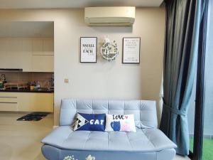 een woonkamer met een blauwe bank met kussens bij ZuncyT11, Medini,Legoland, Gelang Patah, Johor Bahru in Nusajaya