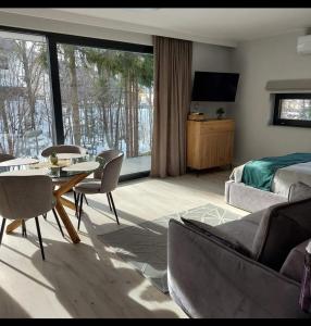 een woonkamer met een bed, een tafel en een televisie bij Apartament Narciarska N°6C in Szczyrk