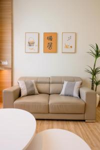 a living room with a couch and a table at MujiZen Retreat Seaview Apartment Amber Cove in Melaka